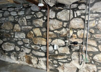 tuckpointing services for interior wall of stone foundation in Stamford, CT