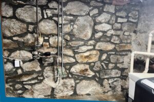 tuckpointing services for interior wall of stone foundation in Stamford, CT